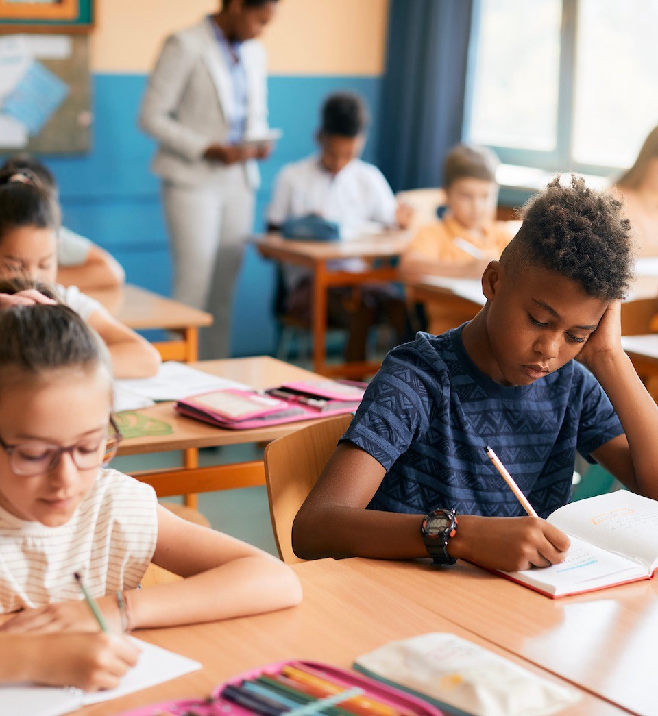Elementary students writing dictation during class in the classroom. Elementary students writing dictation during class in the classroom.